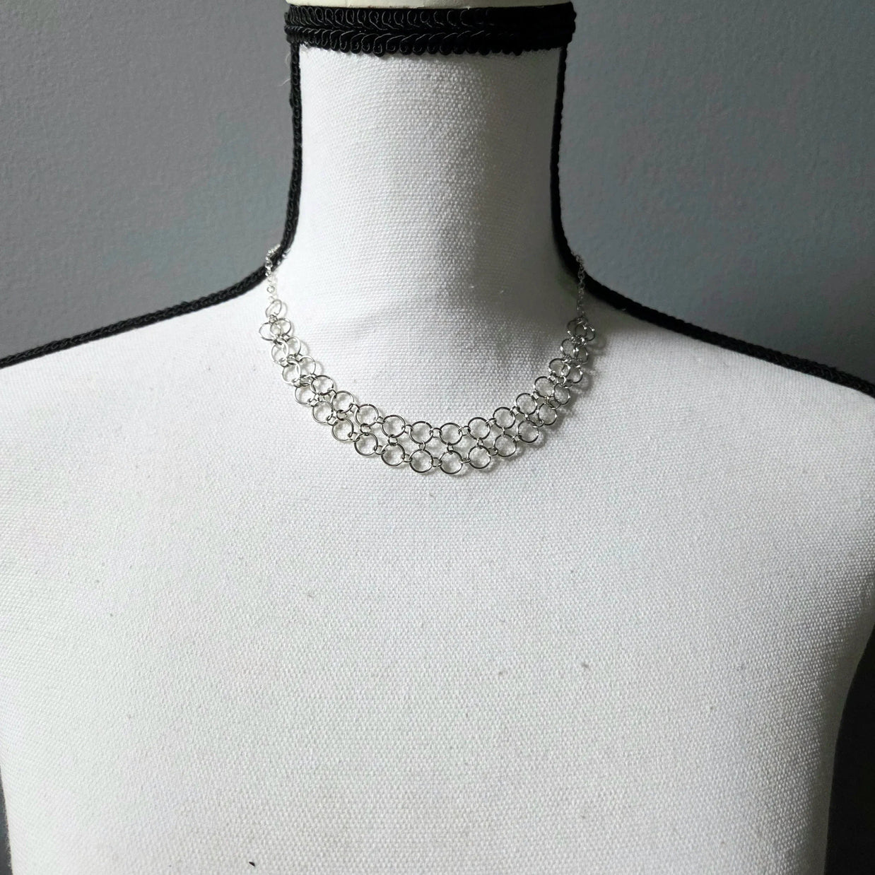 Silver chainmaille choker necklace on white mannequin, delicate handmade jewelry for everyday wear