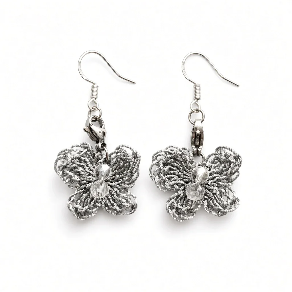 A pair of silver butterfly dangle earrings with textured, woven butterfly charms and clear faceted crystal centers, shown on a plain white background.