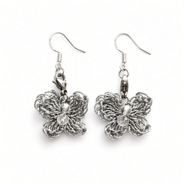 A pair of silver butterfly dangle earrings with textured, woven butterfly charms and clear faceted crystal centers, shown on a plain white background.