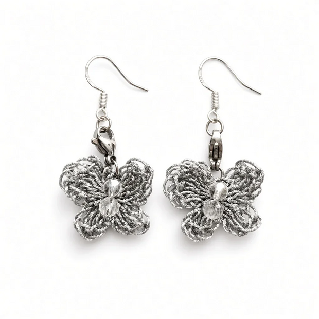 A pair of silver butterfly dangle earrings with textured, woven butterfly charms and clear faceted crystal centers, shown on a plain white background.