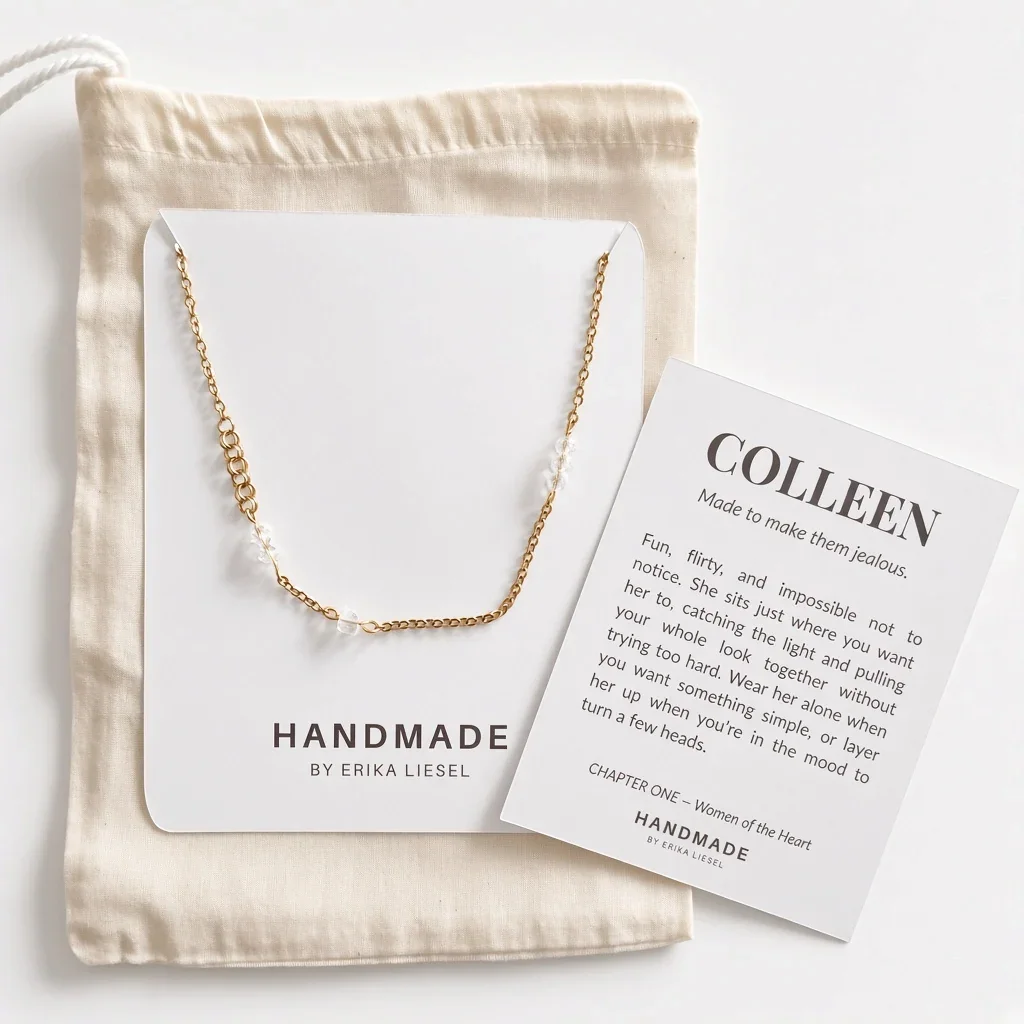 A delicate gold chain necklace is displayed on a white card next to a beige fabric drawstring bag and a printed insert card reading 'COLLEEN' by Handmade by Erika Liesel, arranged on a light neutral background.