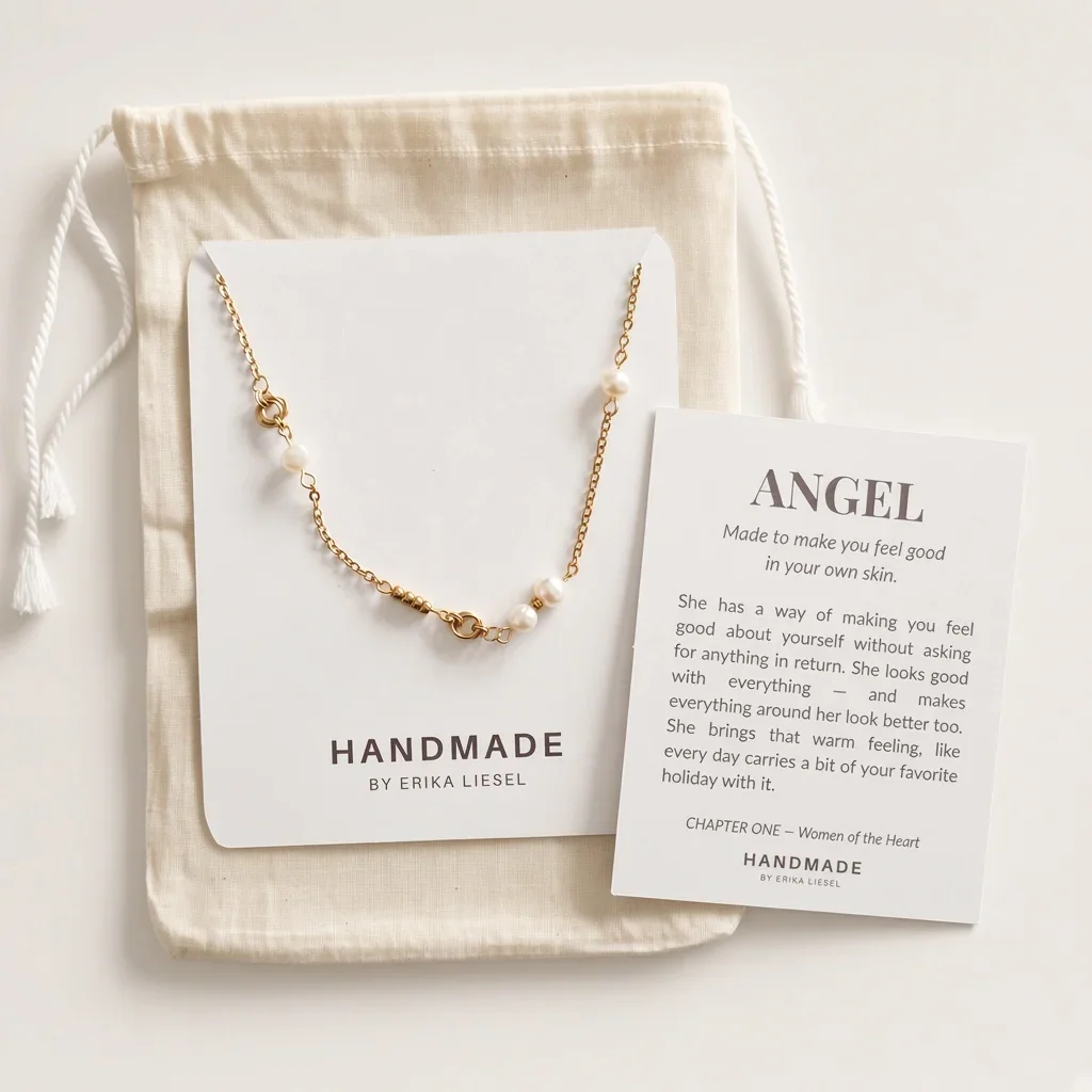 A gold and white pearl necklace displayed on a white card, with a cream drawstring pouch and a printed card titled 'ANGEL' by Handmade by Erika Liesel on a light neutral background.