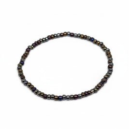 Handmade by Erika Liesel Aurora stretch bracelet featuring dark iridescent glass beads in bronze, purple, and blue.