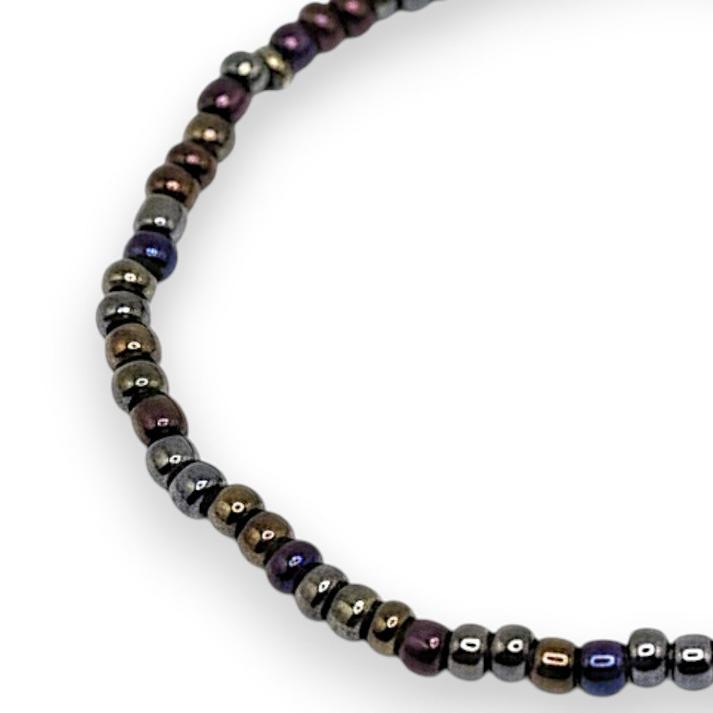 Handmade by Erika Liesel Aurora stretch bracelet with iridescent bronze, purple, blue, and green 3mm glass beads.