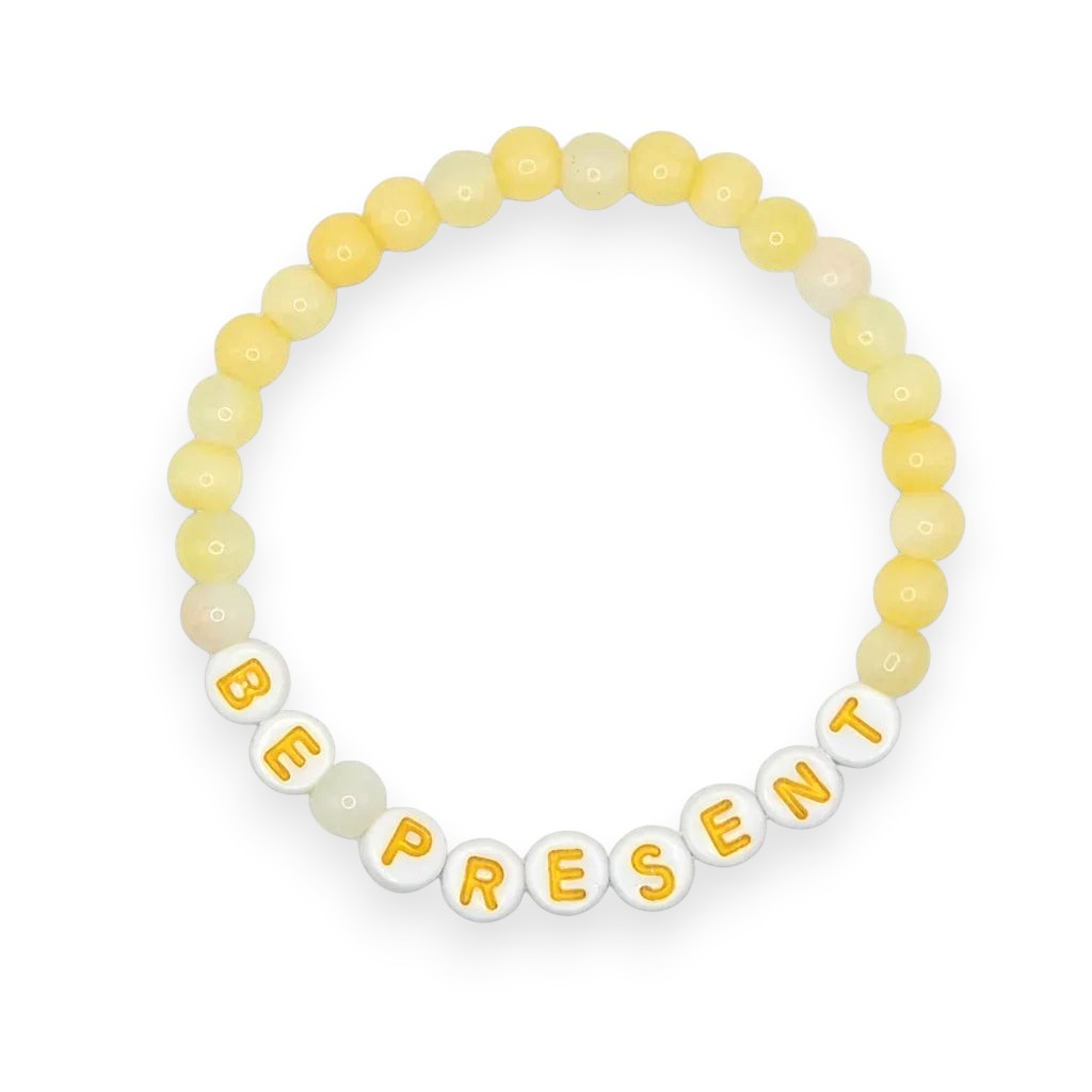Handmade by Erika Liesel Be Present bracelet with soft yellow glass beads and white letter beads on elastic cord.
