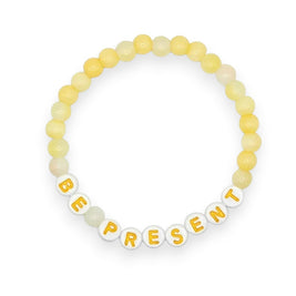 Handmade by Erika Liesel Be Present bracelet with soft yellow glass beads and white letter beads on elastic cord.