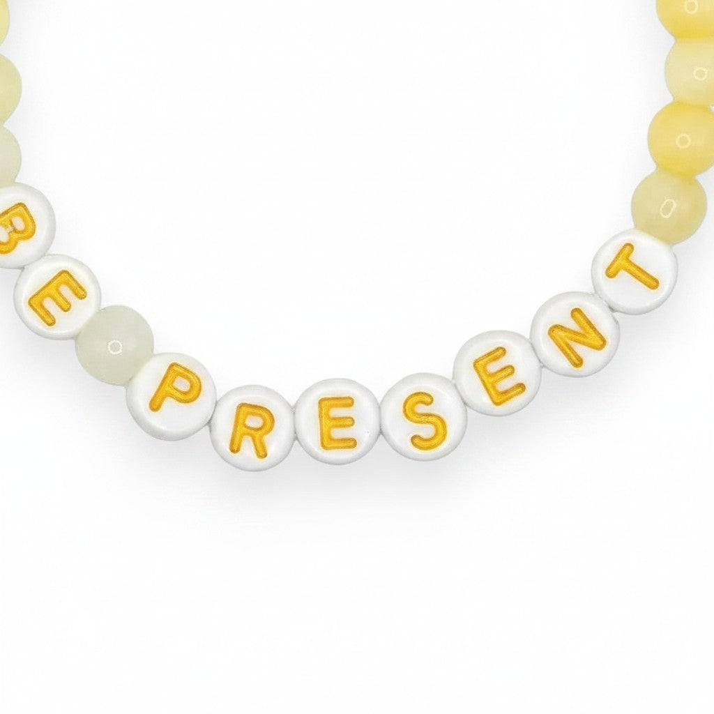 Handmade by Erika Liesel Be Present stretch bracelet with soft yellow glass beads and white letter beads