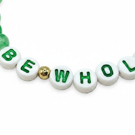 Handmade by Erika Liesel Be Whole bracelet with white letter beads, green text, and green glass accents.