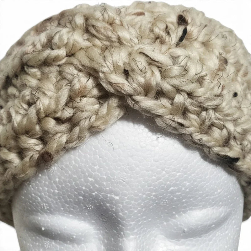 Handmade by Erika Liesel beige chunky crochet ear warmer with a twisted front design on a white mannequin head.