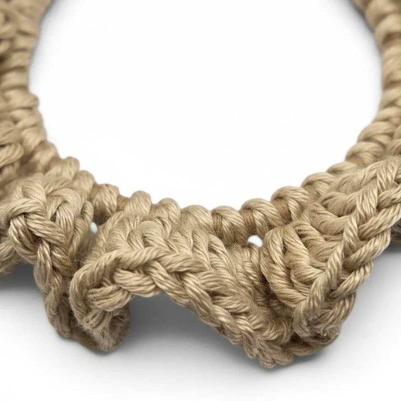 Handmade by Erika Liesel beige crochet scrunchie with textured yarn detail on a white background