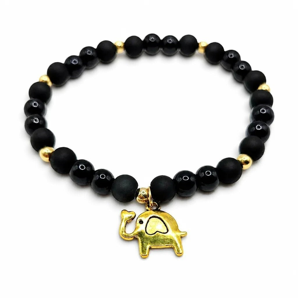 Handmade by Erika Liesel Buena Suerte stretch bracelet with matte and glossy black beads and a gold elephant charm.