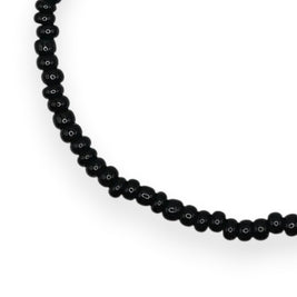 Handmade by Erika Liesel minimalist stretch bracelet featuring small glossy black glass beads on an elastic cord