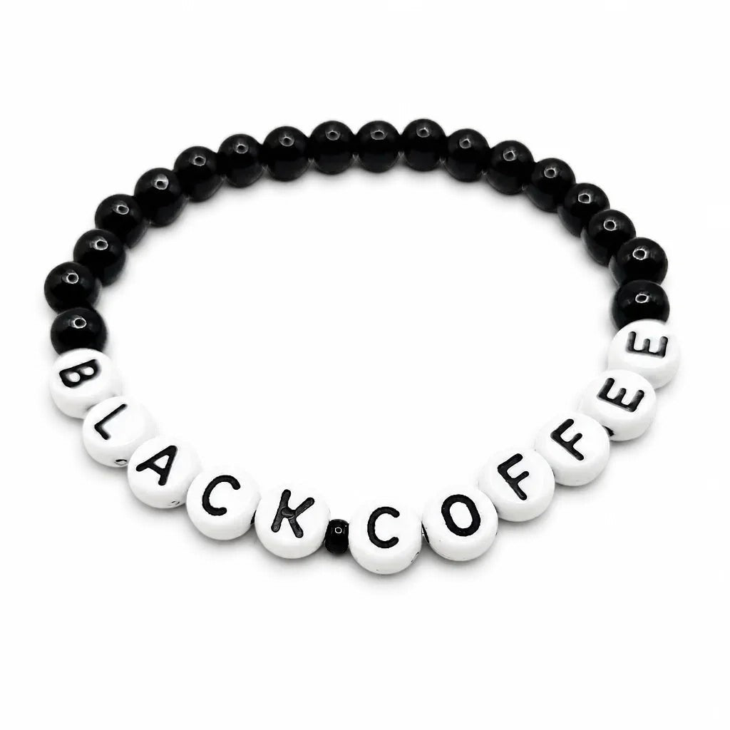 Handmade by Erika Liesel stretch bracelet with 6mm black glass beads and white letter beads spelling BLACK COFFEE