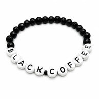 Handmade by Erika Liesel stretch bracelet with 6mm black glass beads and white letter beads spelling BLACK COFFEE