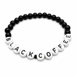Handmade by Erika Liesel stretch bracelet with 6mm black glass beads and white letter beads spelling BLACK COFFEE