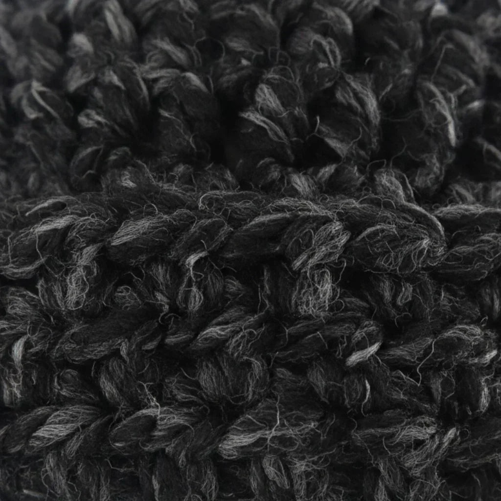 Close-up of a Handmade by Erika Liesel black and grey marled crochet beanie showing the soft, textured yarn detail.