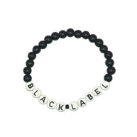 Handmade by Erika Liesel Black Label stretch bracelet with black glass beads and white letter beads on elastic cord.