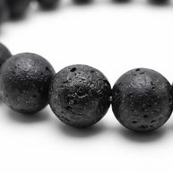 Handmade by Erika Liesel black lava stone bead bracelet with a textured volcanic rock finish on a white background.