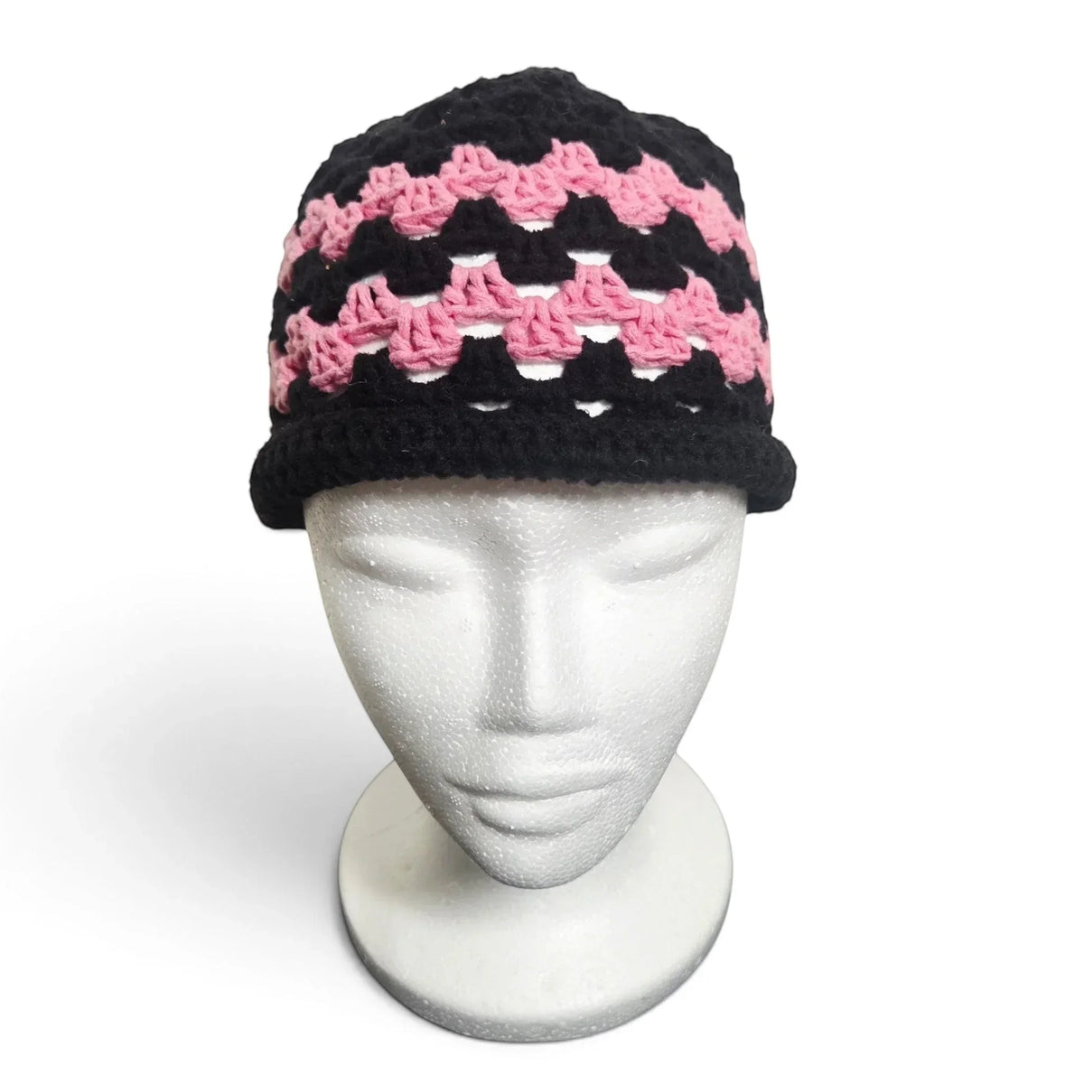 Handmade by Erika Liesel brimless crochet bucket hat in black and pink with a textured, breathable pattern.
