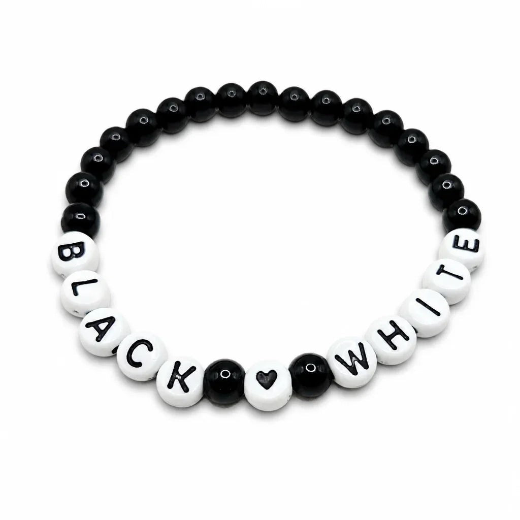 Handmade by Erika Liesel stretch bracelet featuring black glass beads and white letter beads spelling Black White