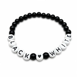 Handmade by Erika Liesel stretch bracelet featuring black glass beads and white letter beads spelling Black White