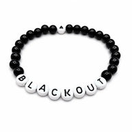 Handmade by Erika Liesel Blackout stretch bracelet with black glass beads and white letter beads on elastic cord.