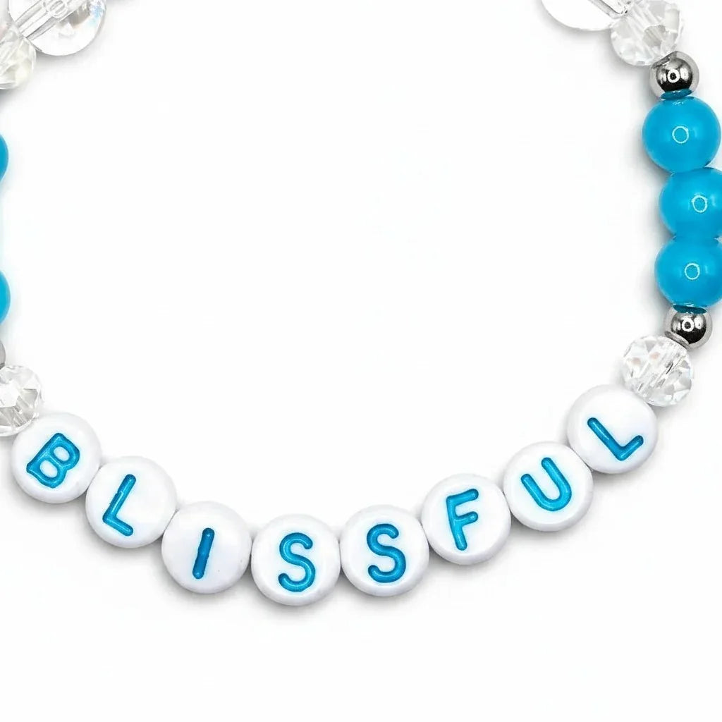 Handmade by Erika Liesel Blissful stretch bracelet with white letter beads, blue accents, and sterling silver details.