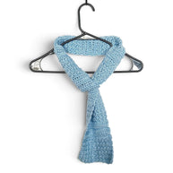 Handmade by Erika Liesel light blue crochet scarf with a convenient keyhole design hanging on a black hanger.