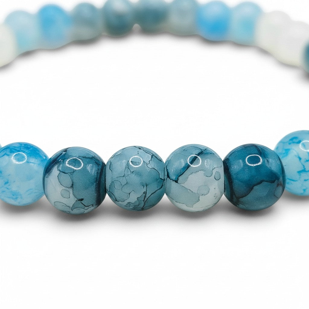Handmade by Erika Liesel stretch bracelet featuring marbled pale blue, icy white, and deep blue 6mm glass beads.