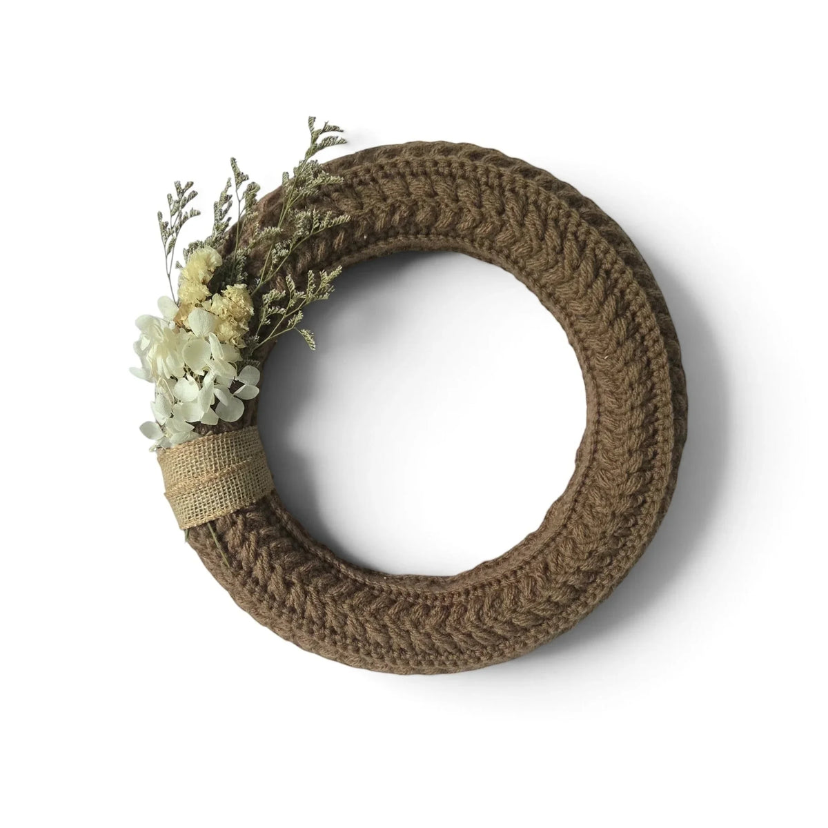 Handmade by Erika Liesel brown crochet wreath with dried floral accents and burlap detail on a white background.