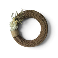 Handmade by Erika Liesel brown crochet wreath with dried floral accents and burlap detail on a white background.