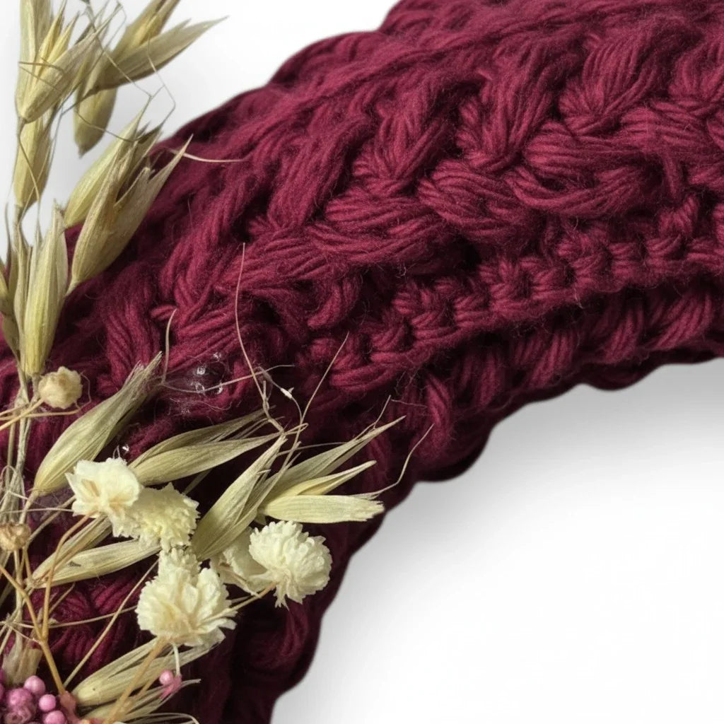 Handmade by Erika Liesel deep burgundy crochet wreath with dried floral accents and textured braided yarn detail.
