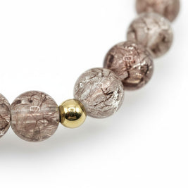 Handmade by Erika Liesel champagne crackle glass bead bracelet with a polished gold-tone accent bead.