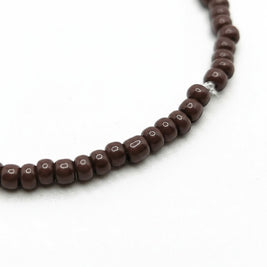 Handmade by Erika Liesel chocolate brown glass bead stretch bracelet on a white background