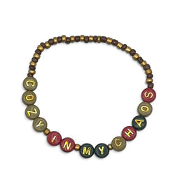 Handmade by Erika Liesel Cozy In My Chaos stretch bracelet featuring 4mm glass beads and gold-foil letter beads.