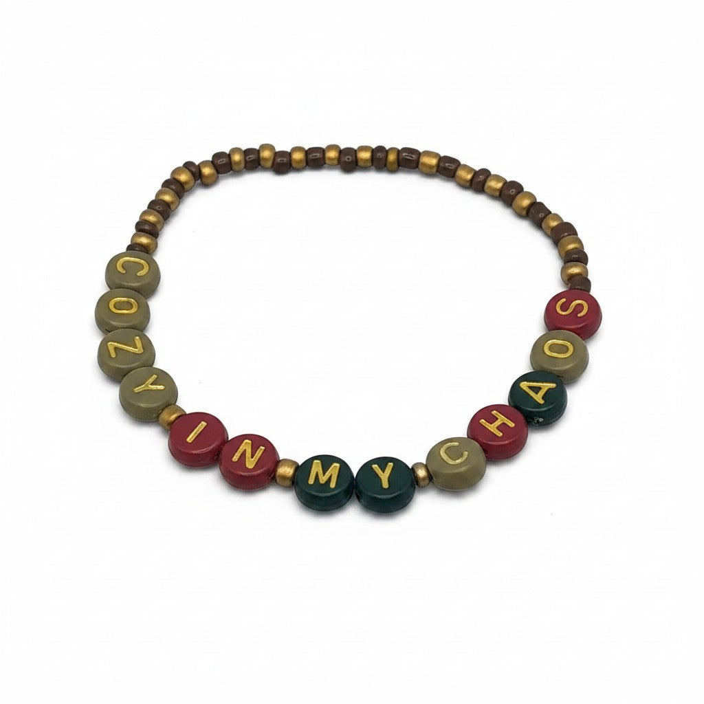 Handmade by Erika Liesel Cozy In My Chaos stretch bracelet with 4mm glass beads and gold-foil letter beads.