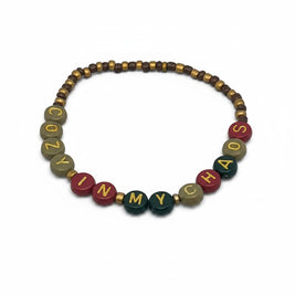 Handmade by Erika Liesel Cozy In My Chaos stretch bracelet with 4mm glass beads and gold-foil letter beads.