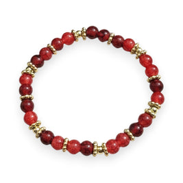 Handmade by Erika Liesel Crimson Charm Bracelet featuring ruby glass beads and gold spacers on a rustic wood surface.