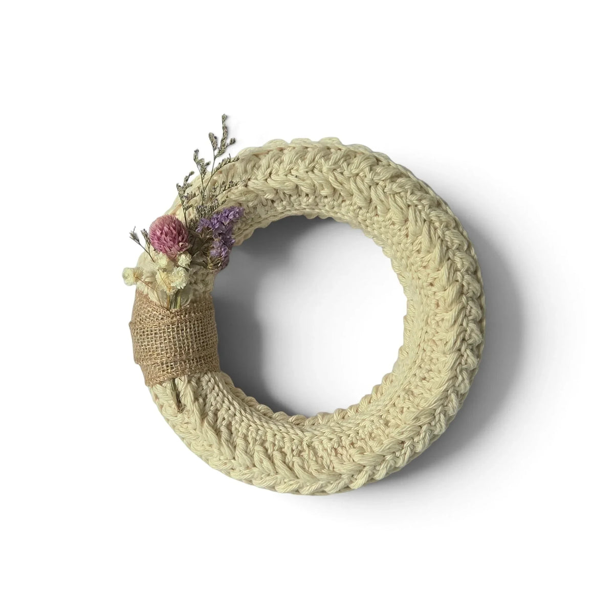 Handmade by Erika Liesel small crochet wreath in neutral cream with dried floral accents and burlap ribbon detail.