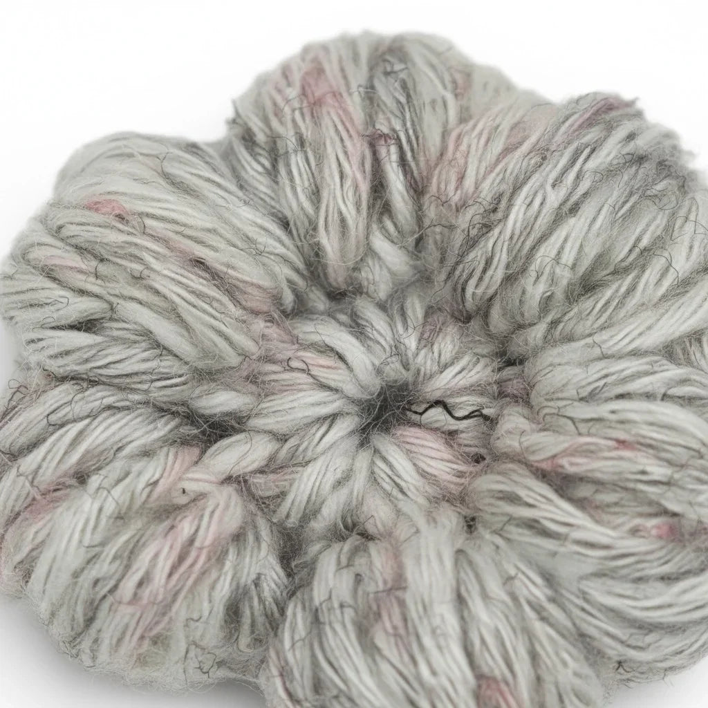 Handmade by Erika Liesel crochet flower barrette in grey and soft pink yarn with a textured, handcrafted finish.