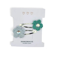 Handmade by Erika Liesel crochet flower snap clips in light blue and green with sparkling rhinestone centers.