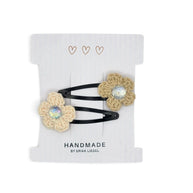 Handmade by Erika Liesel crochet flower snap clips in beige with sparkling rhinestone centers on a display card.