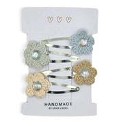 Handmade by Erika Liesel crochet flower snap clips in pastel colors with sparkling rhinestone centers on a display card