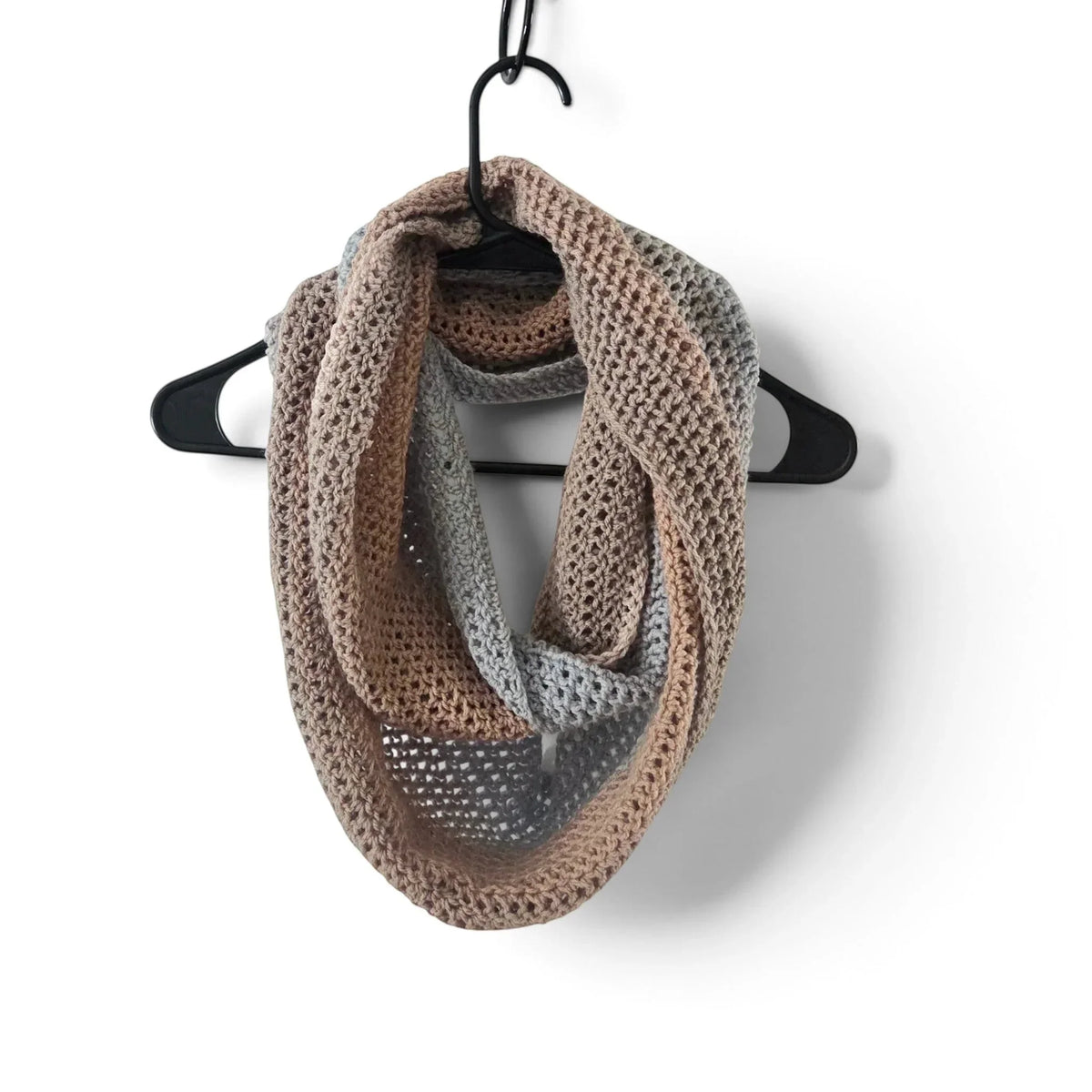 Handmade by Erika Liesel crochet infinity scarf in soft beige and grey acrylic blend yarn on a black hanger