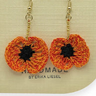 Handmade by Erika Liesel orange and black crochet poppy flower earrings with gold bead accents and gold hooks.