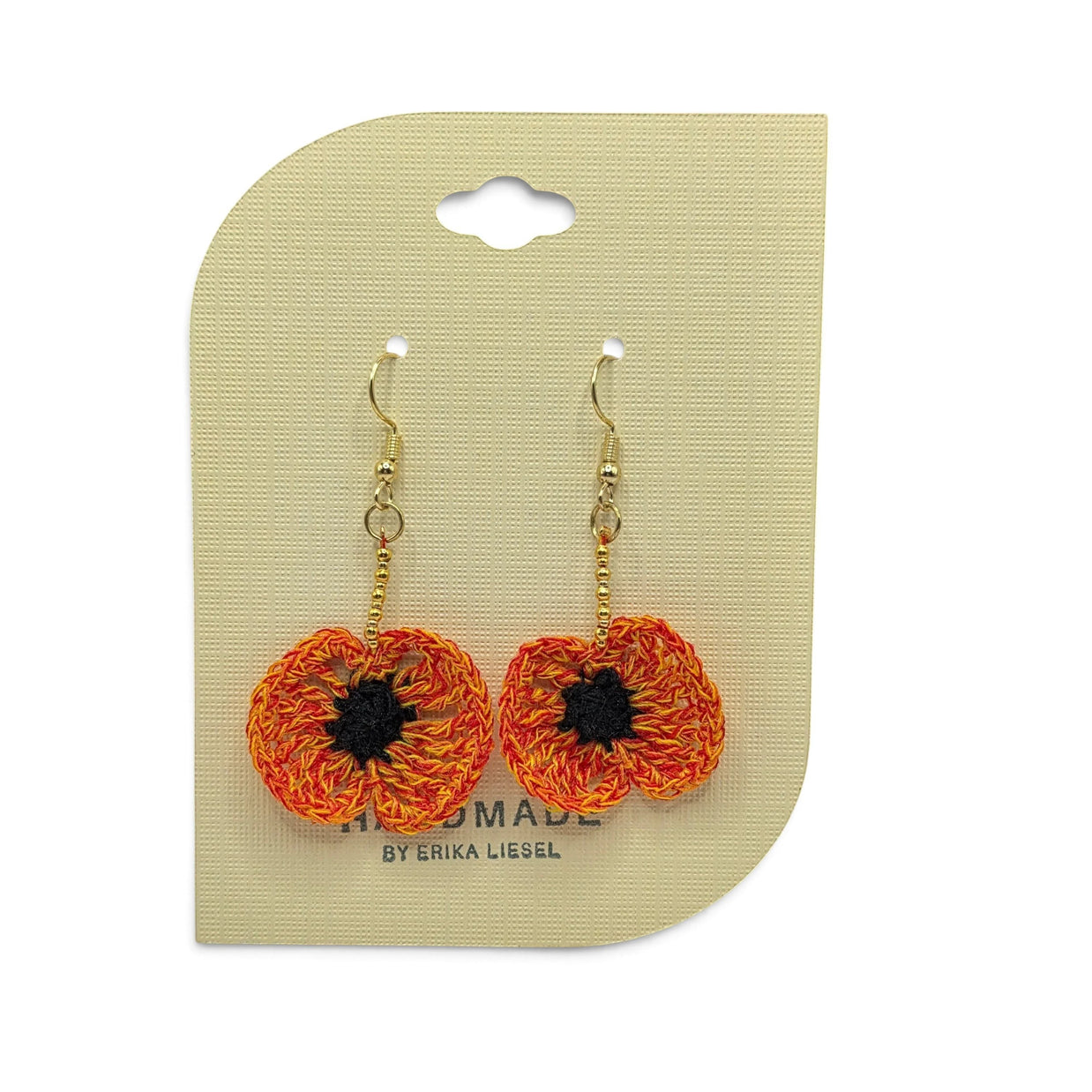 Handmade by Erika Liesel Bloom crochet poppy earrings in orange and black with gold beads on a display card.