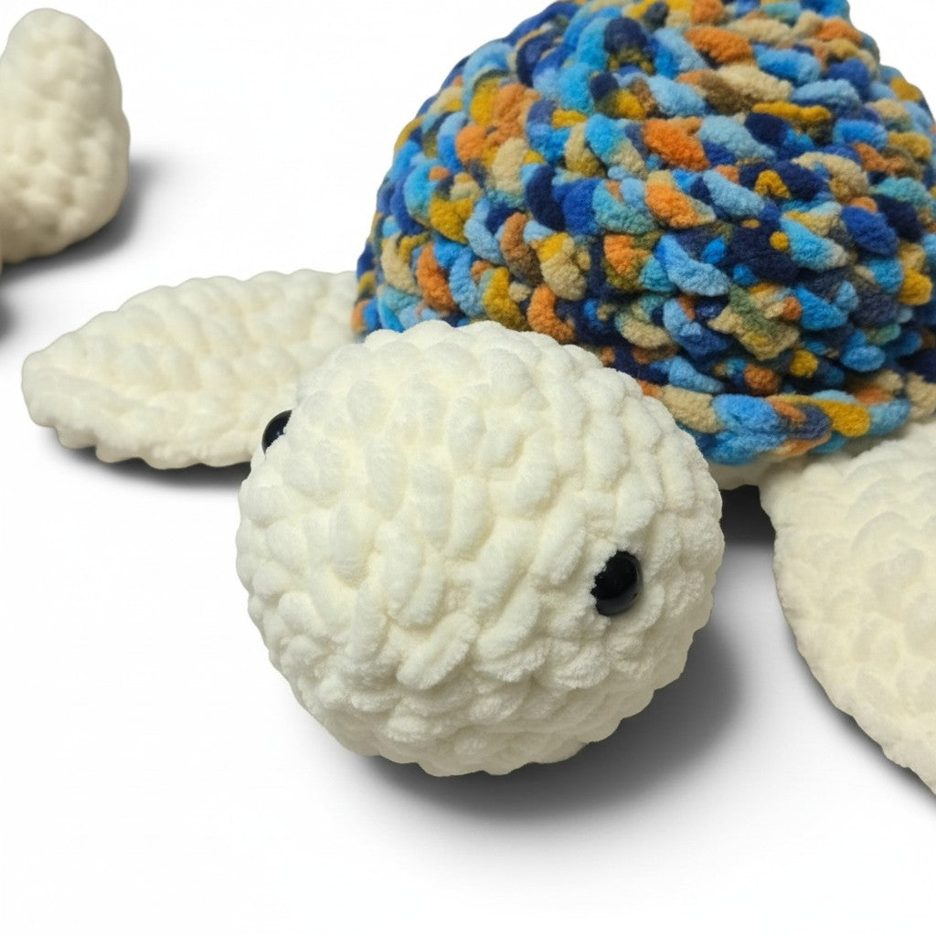 Handmade by Erika Liesel crochet turtle plushie with a multi-colored shell and soft white chenille yarn body.