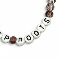 Handmade by Erika Liesel Deep Roots stretch bracelet with smoky brown crackle glass beads and white letter beads.