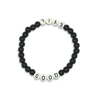 Handmade by Erika Liesel Good & Evil stretch bracelet with black glass beads and white letter beads on elastic cord.