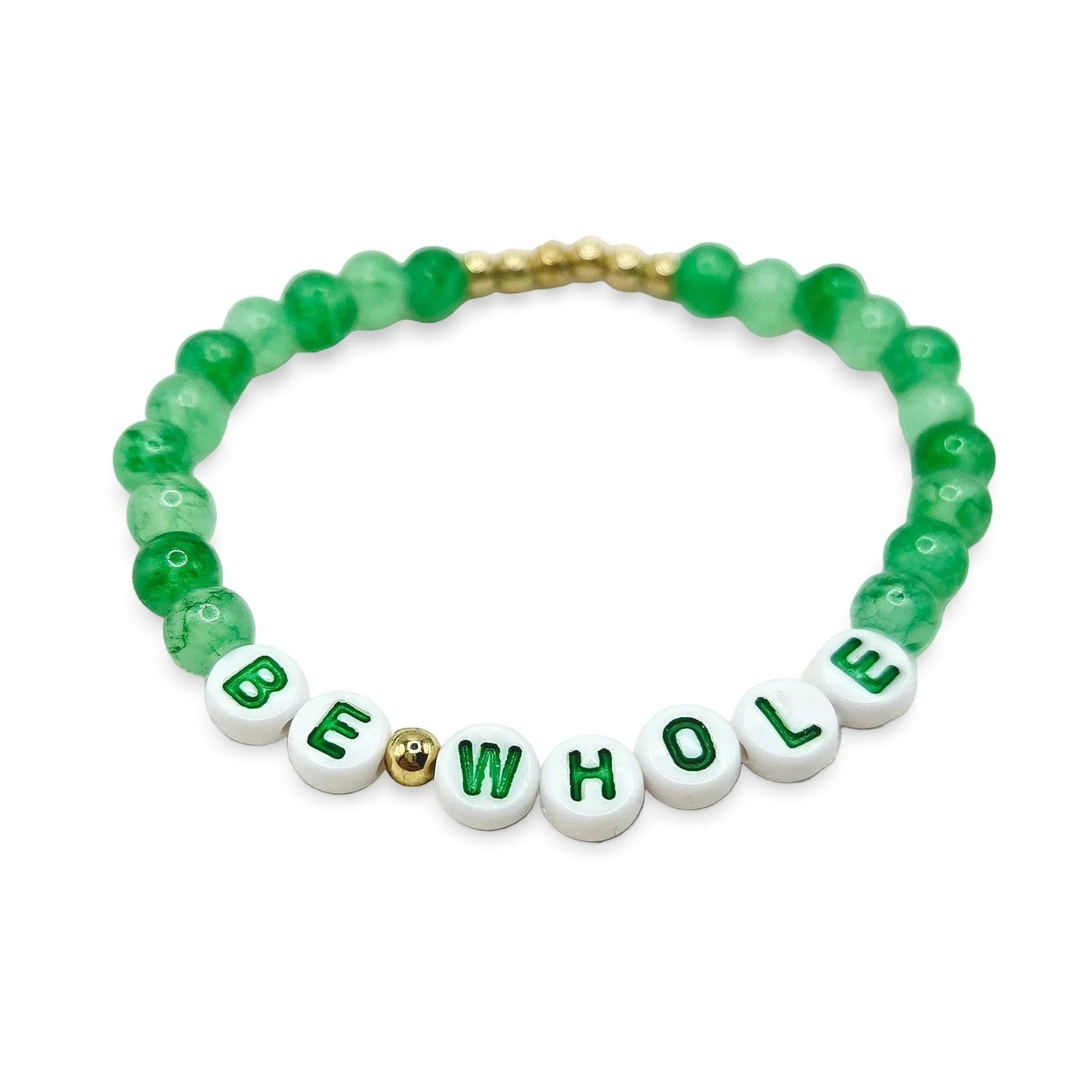 Handmade by Erika Liesel Be Whole bracelet with green glass beads and white letter beads on an elastic cord.